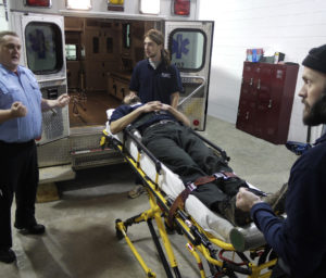 EMT course showing students escort a patient on a stretcher