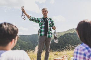A climbing guide reviews climbing gear with clients.